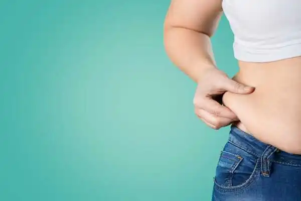 Image of woman pinching her love handles to show weight gain Broxburn